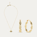 Gold necklace, pendant, and hoop earrings on a white background