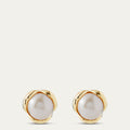Pair of pearl earrings with gold rims on a light beige background