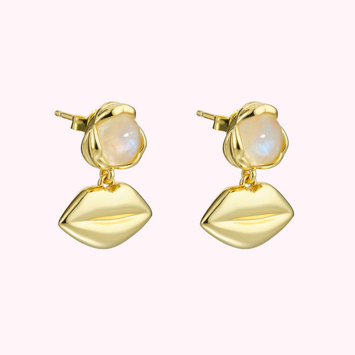 Gold earrings with moonstone accents and lip-shaped charms.