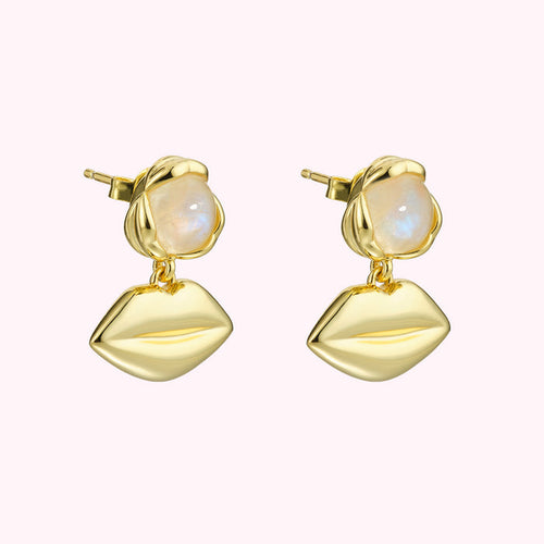 Gold earrings with moonstone accents and lip-shaped charms.