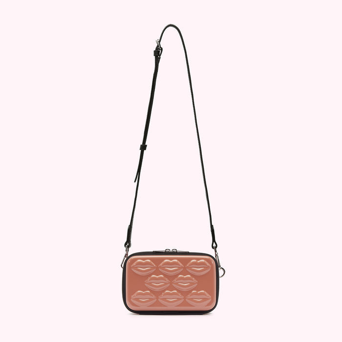 A dusty rose crossbody bag with a black strap and lip-shaped details.