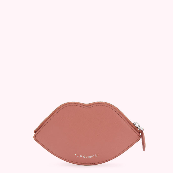 Dusty rose pink lip-shaped zippered coin purse by Lulu Guinness, against a white background.