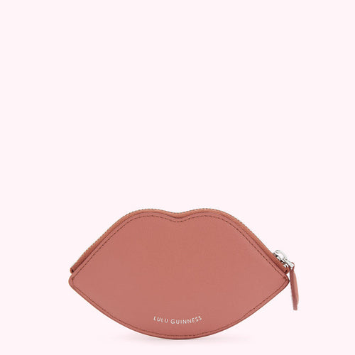 Dusty rose pink lip-shaped zippered coin purse by Lulu Guinness, against a white background.