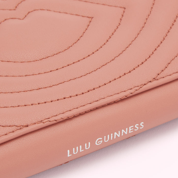 Close-up of a dusty rose Lulu Guinness wallet with quilted lips design.