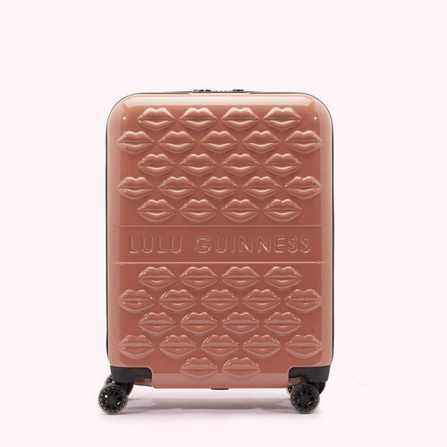 A mauve Lulu Guinness suitcase covered in a repeating pattern of embossed lips.