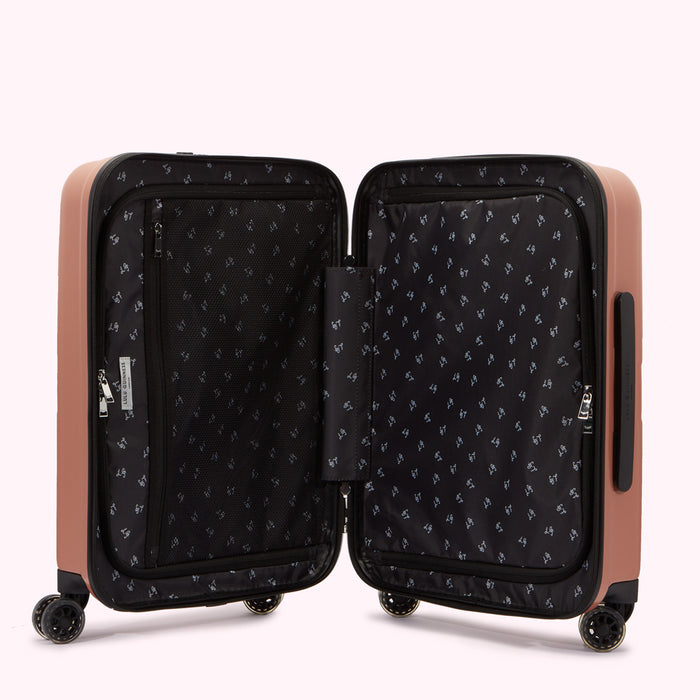 Open rose-gold Lulu Guinness suitcase with black interior showing organizational pockets and a repeating pattern.