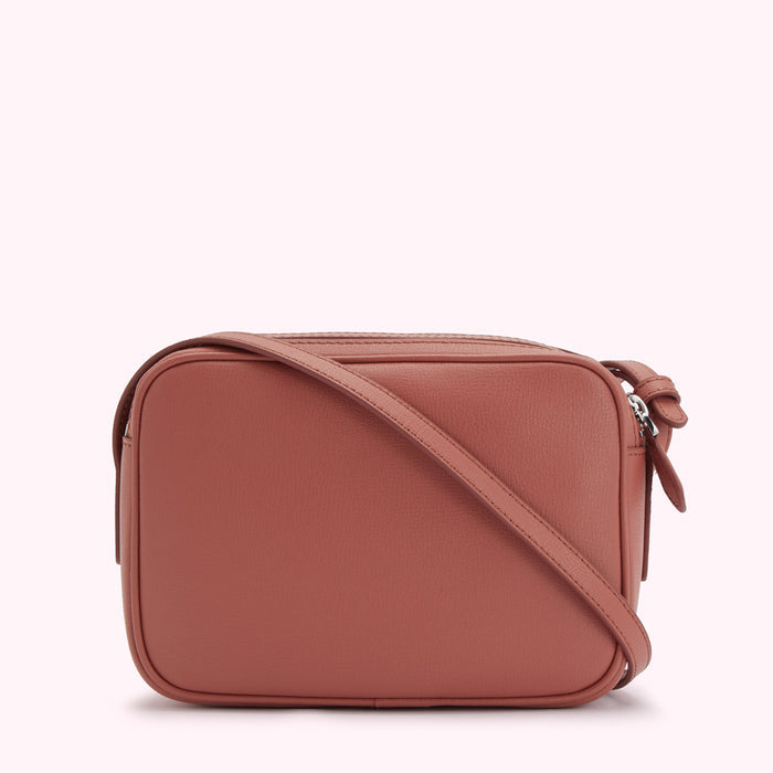 Dusty rose rectangular crossbody bag with a long strap.
