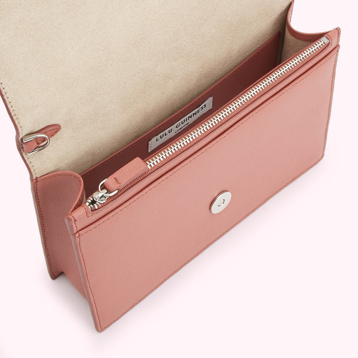 Open blush pink Lulu Guinness crossbody bag with zipper closure and beige interior.