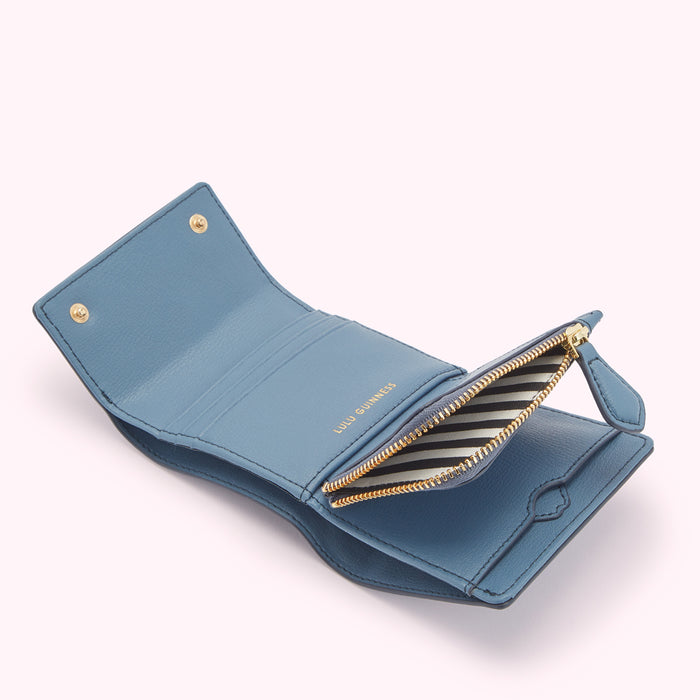 Open blue Lulu Guinness leather wallet with gold zipper and branding.