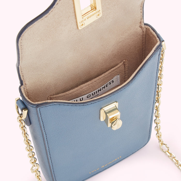 A powder blue Lulu Guinness crossbody bag with gold hardware and chain strap. The bag is open, showing a beige interior.