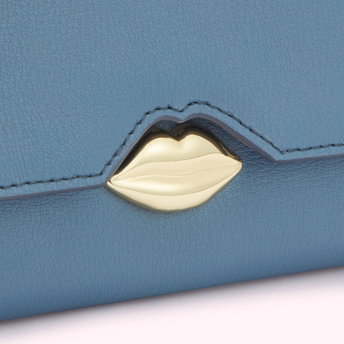 Close-up of a blue leather wallet with a gold lip-shaped clasp.