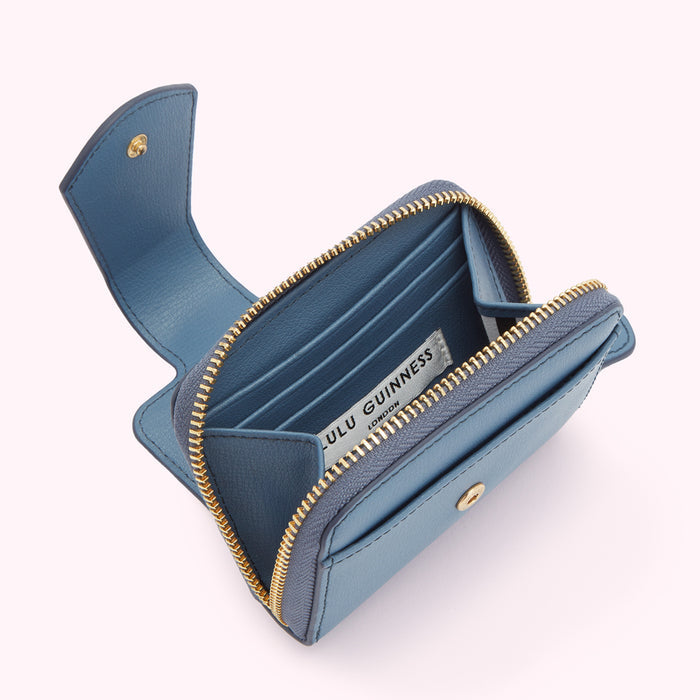 Open blue Lulu Guinness zip-around wallet on white background.