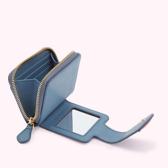 A blue leather compact wallet with a built-in mirror, open to display the interior card slots and zipper.
