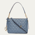 Blue quilted handbag with gold accents on a light gray background