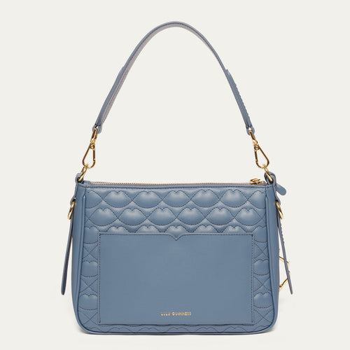 Blue quilted handbag with gold accents on a light gray background
