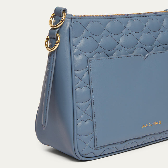Blue handbag with gold accents on a light gray background