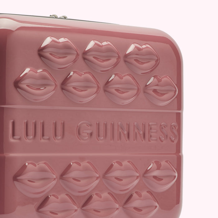 Pink Lulu Guinness suitcase with embossed lips and logo.