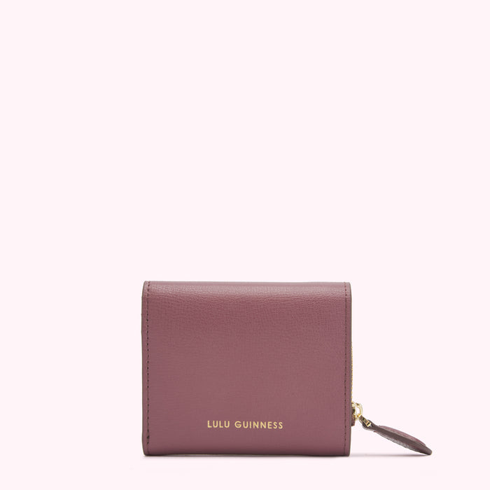 A dusty rose Lulu Guinness zip-around wallet against a white background.