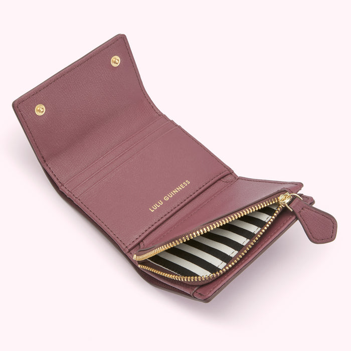 Open mauve Lulu Guinness wallet with black and white striped interior.