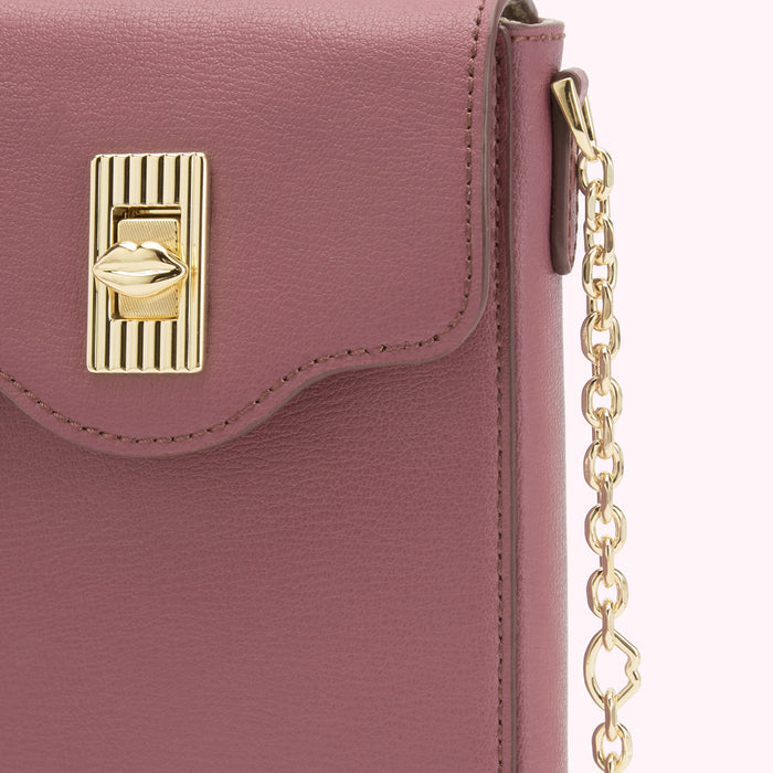 Close-up of a dusty rose-coloured crossbody bag with a gold lip-shaped clasp and chain strap.