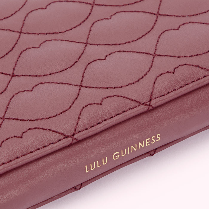 Close-up of a burgundy Lulu Guinness wallet with a quilted lip print design.