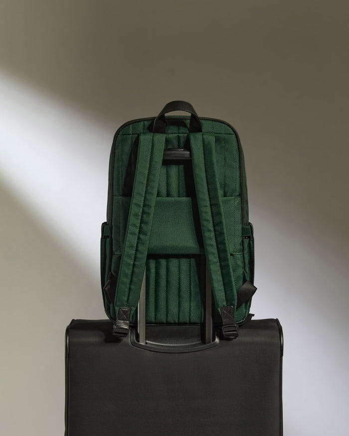 a green backpack on a black suitcase