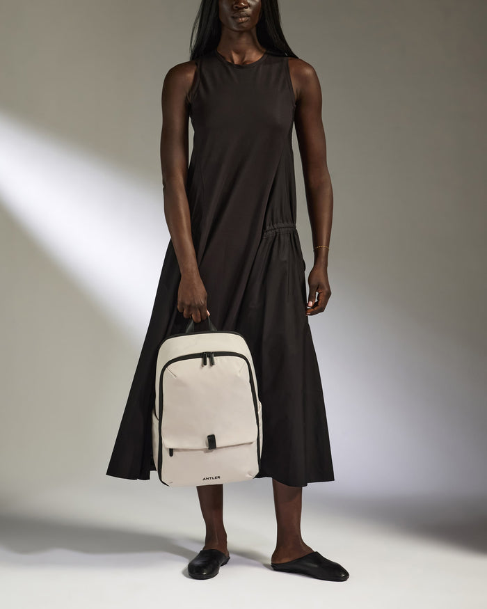 a man in a black dress holding a backpack