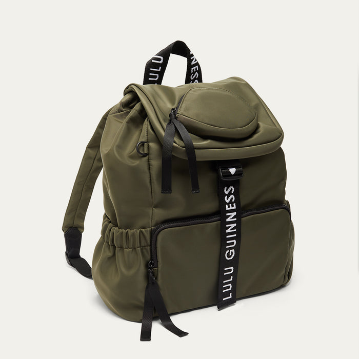 Green backpack with black 'Lulu Guinness' branded straps on a white background