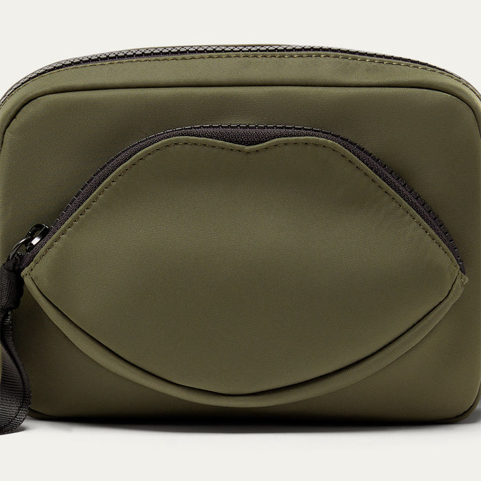 Green crossbody bag with a black zipper on a white background
