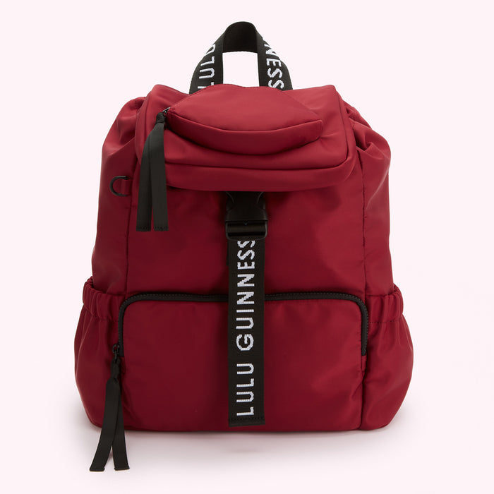 Red Lulu Guinness backpack with black straps and zipper.
