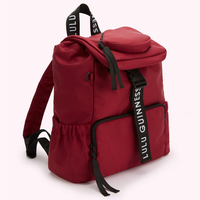 Burgundy Lulu Guinness backpack with black straps and zipper detailing.