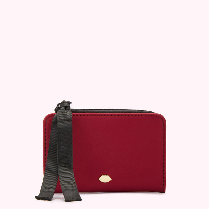 Red card holder with black ribbon and gold lip detail against a white background.