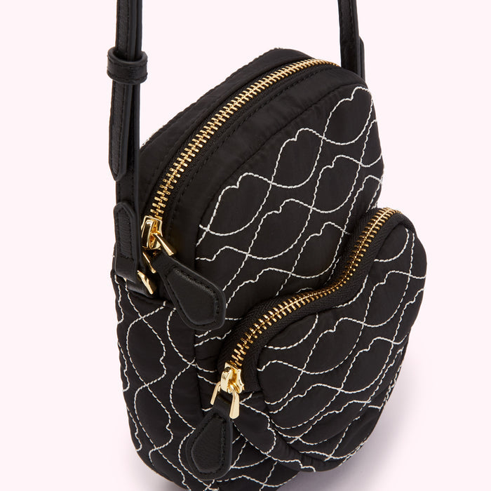 Black quilted crossbody bag with white stitching in a lip pattern, gold zippers.