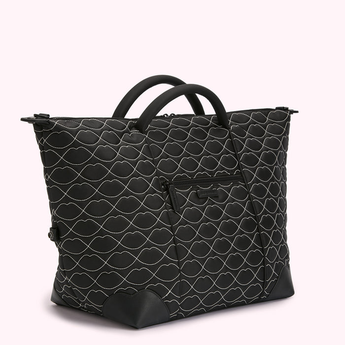 Black quilted tote bag with a lip print.
