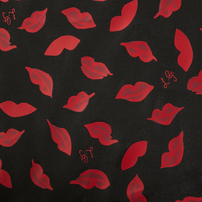 Close-up view of a black fabric with a repeating pattern of red lips.