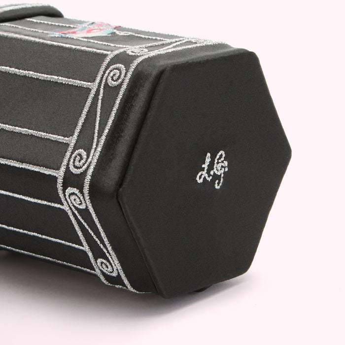 Close-up of a black hexagonal box with silver embroidery and the LG logo.