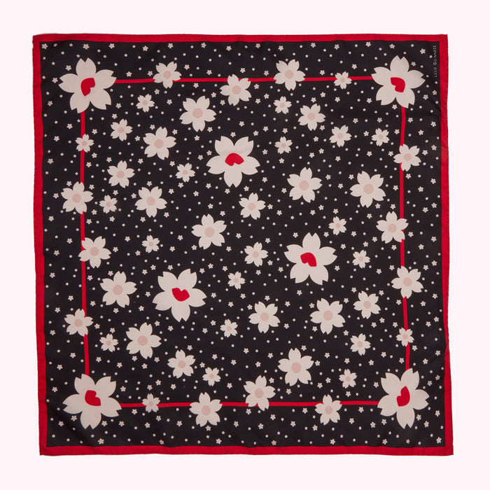 Black silk scarf with a red border and a pattern of stylized cherry blossoms.