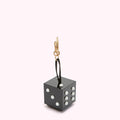 Black die-shaped keychain with white dots against a white background.