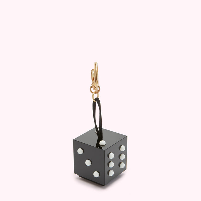 Black die-shaped keychain with white dots against a white background.