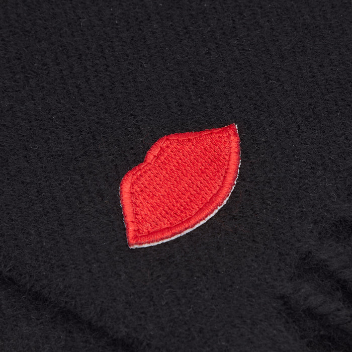 Close-up of a red lips patch embroidered onto a black fabric.
