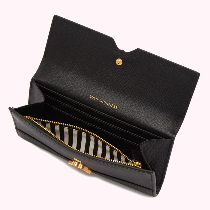 Open black Lulu Guinness wallet with gold zipper and clasp, black and white striped interior.