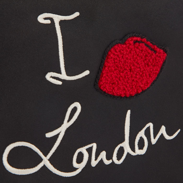 Close-up of a black textile with white embroidery that says "I Love London" and a red embroidered lip.