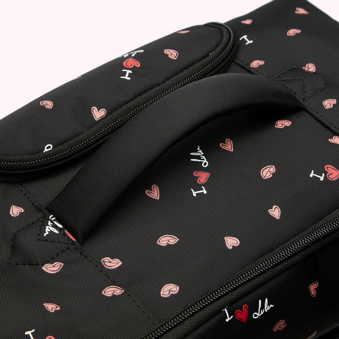 Close-up of a black backpack with a pink and white "I love lulu" pattern and a top handle.