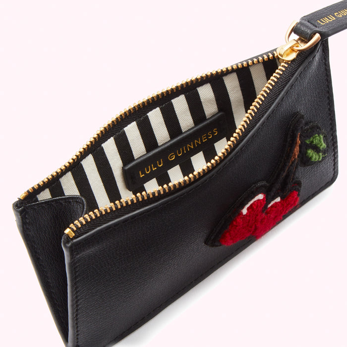 Black Lulu Guinness cardholder with red cherry embroidery and black and white striped interior.