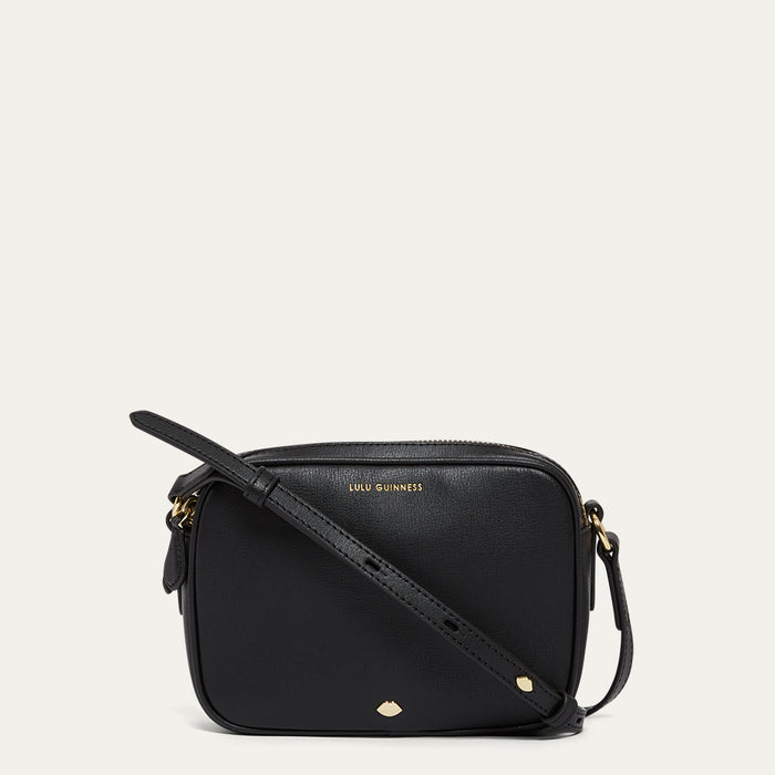 Black handbag with gold accents on a light grey background