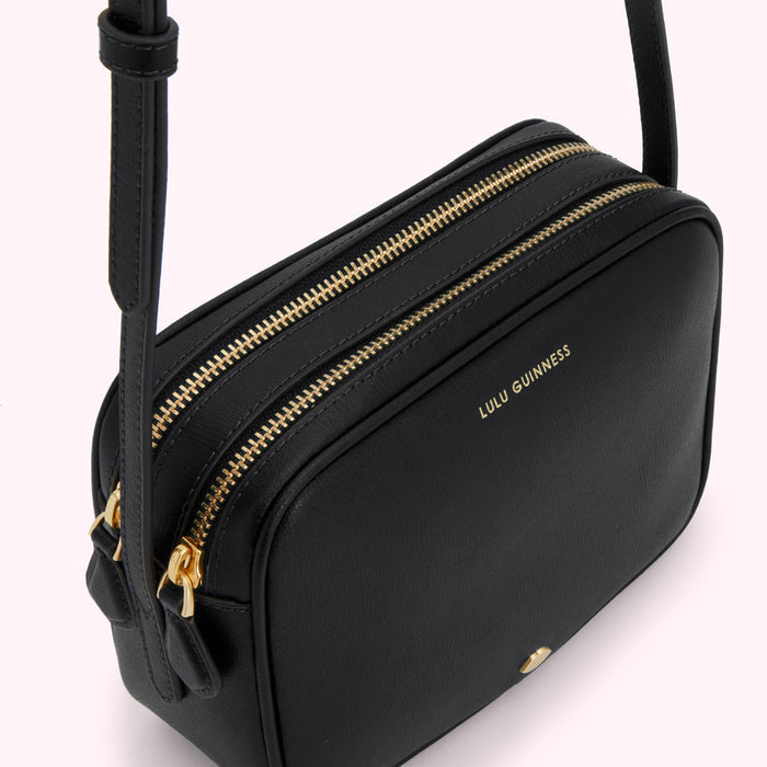 Black Lulu Guinness crossbody bag with gold zippers.
