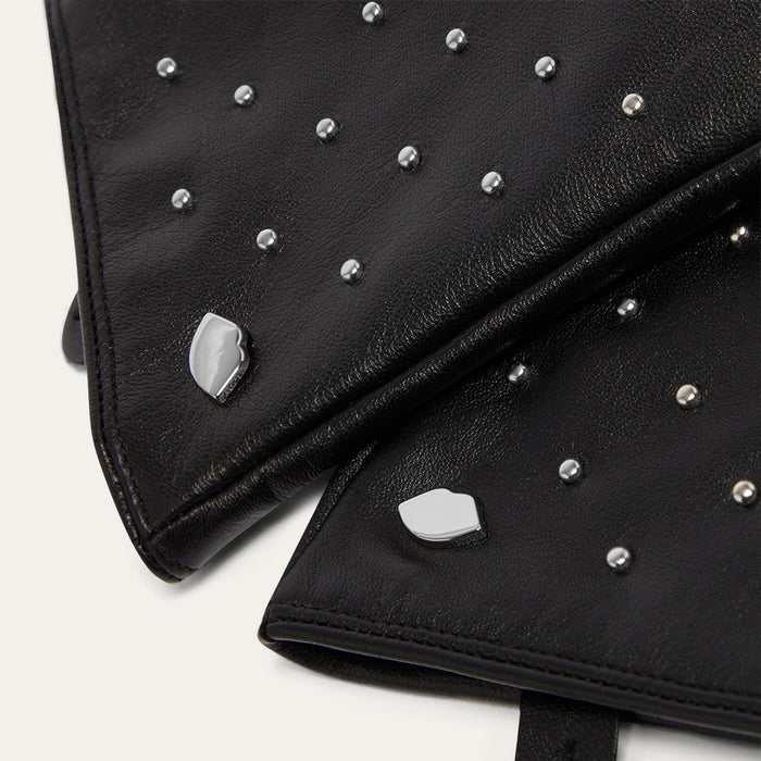 Black leather gloves with silver studs on a white background