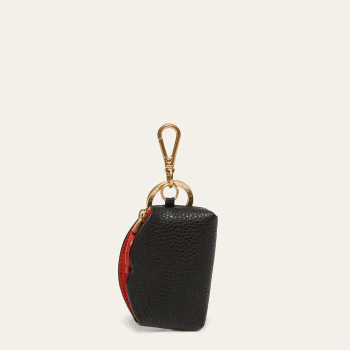 A small black pebbled leather pouch with a gold-tone lobster clasp and ring, featuring a red interior lining visible on the side, set against a light off-white background.