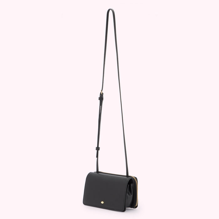 A black leather crossbody bag with a long crossbody strap with a buckle fastening.