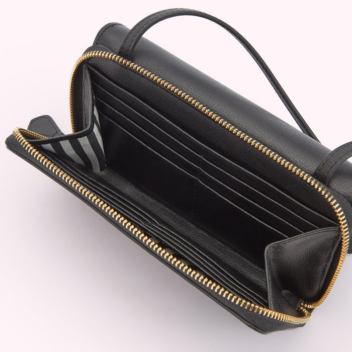 Inside image of a black leather crossbody bag with a gold metal zipper. Showing the inside compartment with card slots.